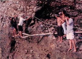 Warga merayap di dinding karang gua dengan tali dan bambu