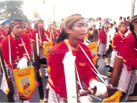 Arak-arakan para pria pembawa musik tradisional dalam kelompok pergelaran seni Purbamas